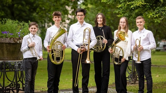 Bild des Ensembles Young Brass: Jugendliche mit Blechblasinstrumenten stehen in einem Park