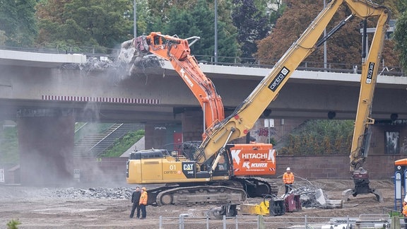 Bagger arbeiten auf der Altstädter Elbseite an dem hängende Trassenteil vom Rest der Carolabrücke