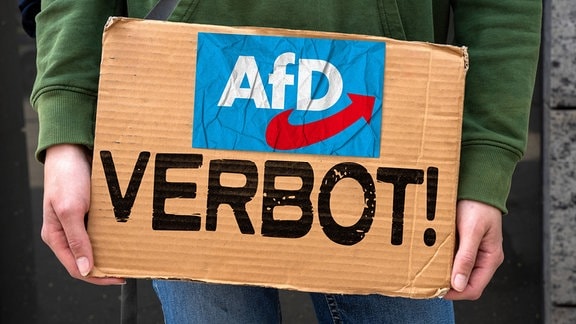 Symbolbild: Eine Person hält ein Pappschild mit der Aufschrift: AfD Verbot, in den Händen.