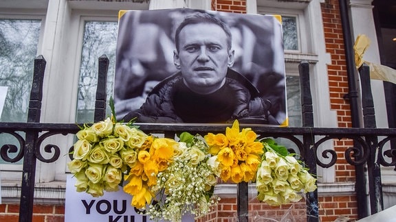 Foto von Alexej Nawalny und Blumen vor der russischen Botschaft in London