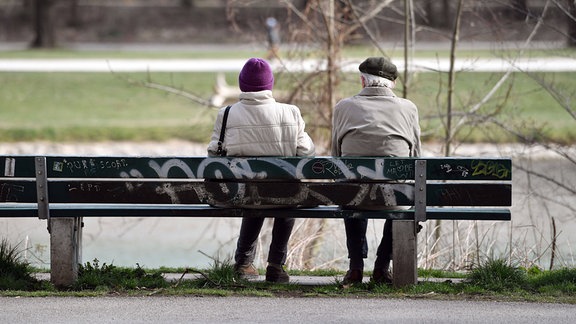 Rentner -Mann und Frau, sitzen auf einer Bank