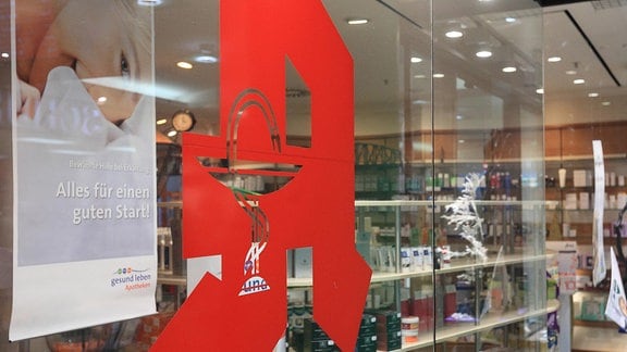 Das Apotheken-Logo an der Schaufensterscheibe einer Apotheke