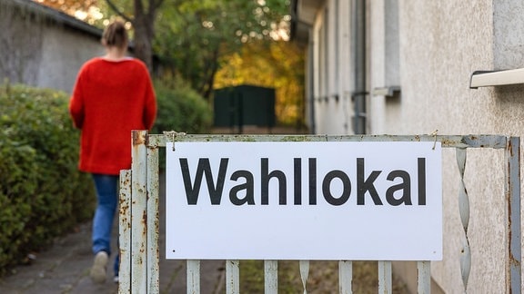 Eine Wahlhelferin läuft in ein Wahllokal