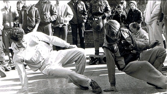 Historische Schwarzweiß-Aufnahme: Breakdance-Formation beim Tanzen