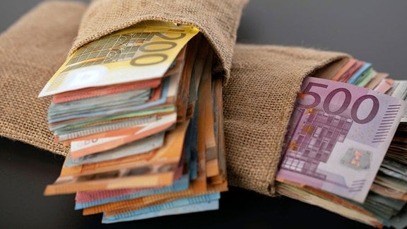 Euro-Geldscheine in kleinen Säcken.