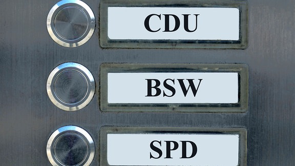 In drei Klingelschildern stehen die Parteinamen von CDU, BSW und SPD.