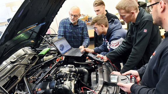 Angehende KFZ-Mechatroniker bereiten im Bereich Fahrzeugtechnik an den Berufsbildenden Schulen Anhalt-Bitterfeld unter der Leitung von Berufsschullehrer Thomas Arnold (l) eine Fahrzeugdiagnose vor.