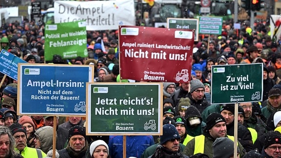 Teilnehmer einer Kundgebung des Bauernverbands stehen mit Schildern und Transparenten auf dem Juri-Gagarin-Ring in Erfurt
