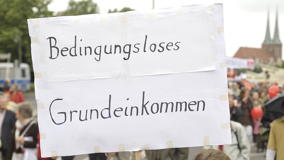 Bedingungsloses Grundeinkommen steht auf einem Schild