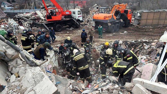 Mitarbeiter des Katastrophenschutzministeriums bei der Arbeit in einem zerstörten Gebäude in Nikolskoje