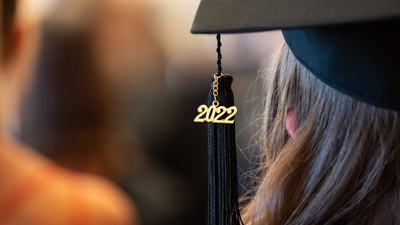 Eine Frau trägt bei einer Abschlussfeier ihrer Universität einen Absolvationshut. 