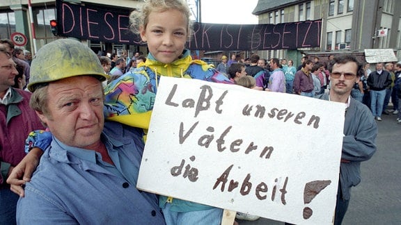 So wie dieses kleine Mädchen boykottierten am 06.07.1993 Hunderte Kinder mit ihren Lehrern aus dem Kaliort Bischofferode und der näheren Umgebung des Unterricht und zogen mit Transparenten vor die Werktore des besetzten Kalischachtes.