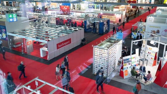 Besucher gehen  auf der Frankfurter Buchmesse durch eine Halle.