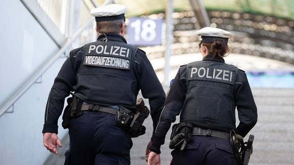 Polizeikommissar Ronny Forke (l) und Polizeikommissarin Catharina Lambertz gehen im Hauptbahnhof auf einen Bahnsteig