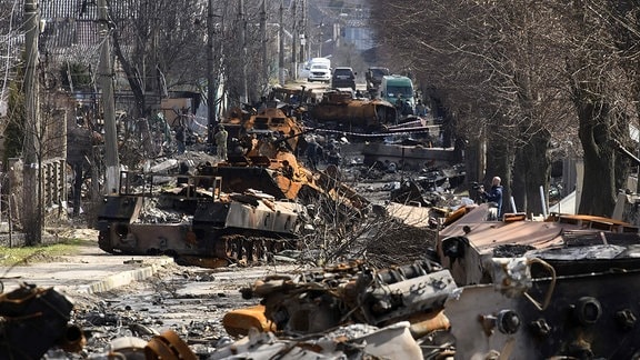 Straße mit zerstörtem Kriegsgerät in Butscha