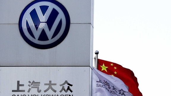 Eine chinesische Fahne weht neben einer Vertretung von SAIC Volkswagen