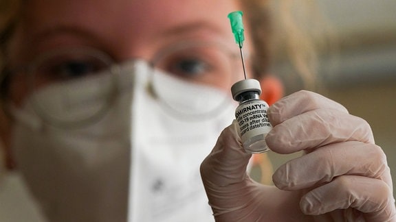 Die Impfschwester Antonia Hollerbach hält eine Ampulle Impfstoff Comirnaty (BioNTech) zum Aufziehen einer Impfspritze
