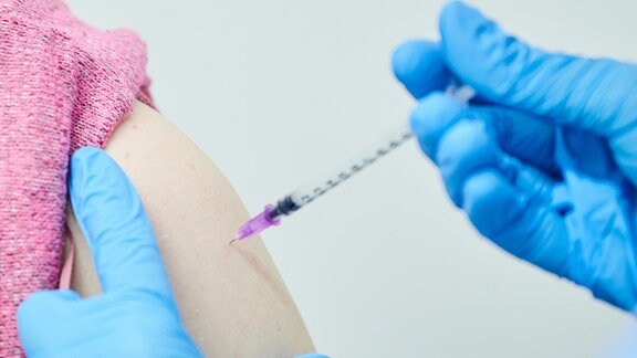 Eine Frau bekommt ihre Auffrischungsimpfung mit dem neuen angepassten Impfstoff.