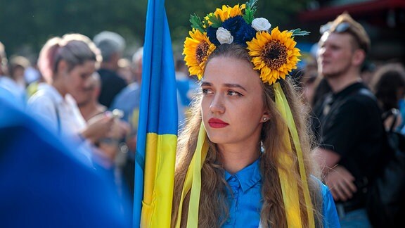 Eine Demonstrantin mit Blumen im Haar auf dem Demo am Ukraine Nationalfeiertag