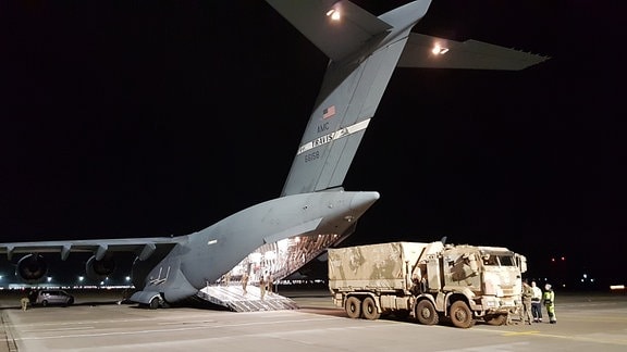Ein Bundeswehr-Lkw wird aus einer Transportmaschine der US Air Force auf dem Flughafen Leipzig/Halle entladen.