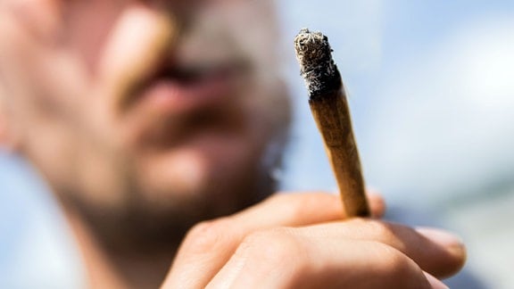 Ein Mann raucht einen Joint bei einer Demonstrationen für eine zügige Legalisierung von Cannabis.