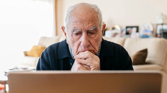 Senior vor einem Laptop