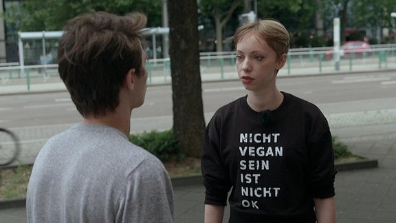 Eine Frau im Interview trägt ein T-Shirt mit der Aufschrift: "Nicht vegan sein, ist nicht ok."