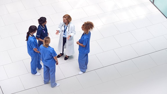 Ärztinnen und Pflegepersonal stehen in einem Kreis (Symbolbild)