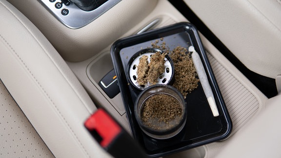 Cannabis, Grinder und ein Joint im Auto.