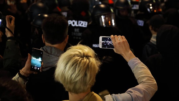 Demonstrierende filmen Polizisten.