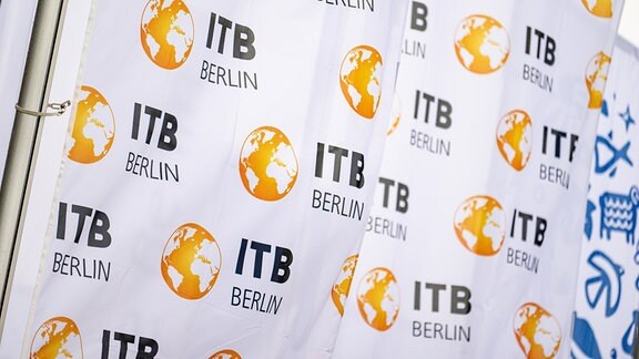 Fahnen mit dem Logo vor der Messe Berlin wehen vor der Eröffnung der Internationalen Tourismus-Börse (ITB).