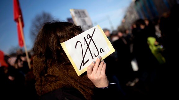 Demonstranten mit Schild "Stop 219a"