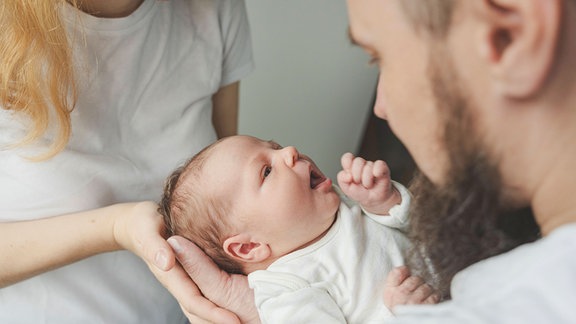 Vater und Mutter halten ihr Baby