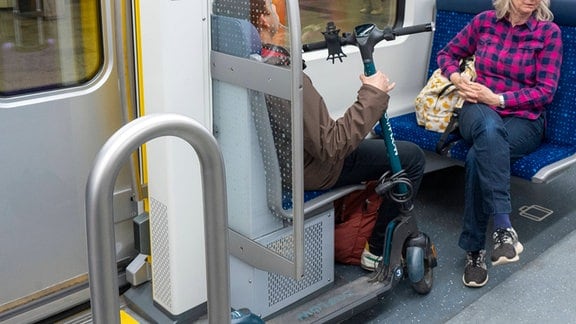 Ein Fahrgast hat in einer S-Bahn einen E-Roller dabei.