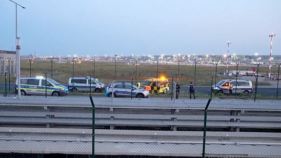 Einsatzfahrzeuge der Polizei stehen unweit des Rollfelds am Frankfurter Flughafen.