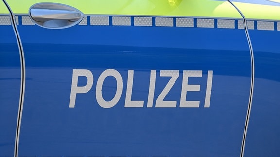 Das Wort Polizei ist an einer Tür eines Einsatzfahrzeugs der Polizei angebracht.