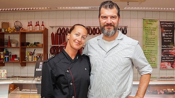 Ein Metzger und eine Frau in einer Metzgerei.