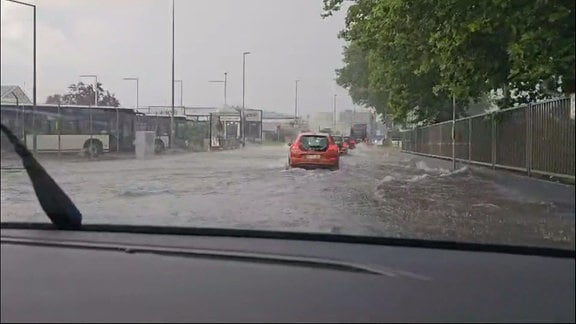 überflutete Straße, Autos fahren durch