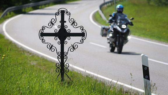 Ein Motorrad fährt auf der Bundesstrasse 16 bei Stetten hinter einer mit einem Kreuz markierten Unfallstelle.