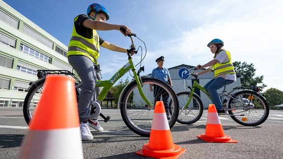 Schülerinnen und Schüler einer vierten Klasse nehmen auf dem Hof der Grundschule an einer Verkehrsschulung der Verkehrswacht Sachsen teil.