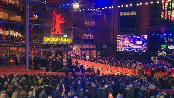 Eine Menschenmenge um einen noch leeren roten Teppich, vor dem Berlinale Palast in Berlin.