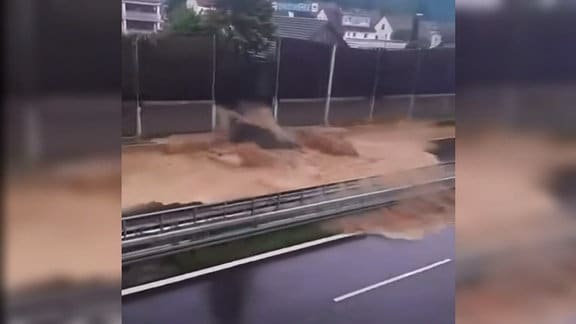 Wasser durchbricht an einer Bundesstraße eine Läumschutzwand