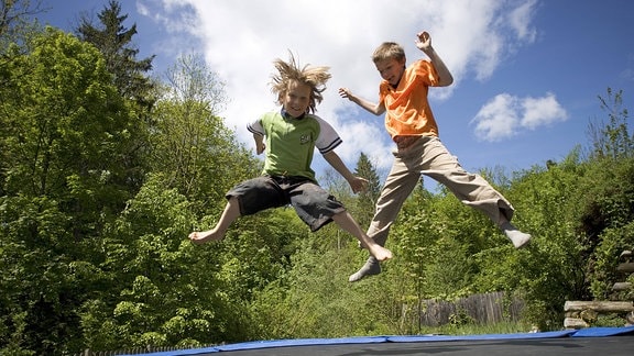 Zwei Jungs springen auf einem Trampolin