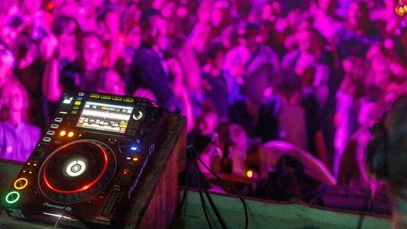 DJ-Pult vor Tanzpublikum