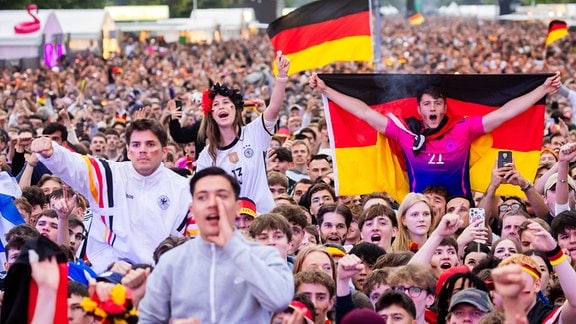 Eine bunte Menschenmasse: Deutschland-Fans feiern mit Deuitschlandfahnen und anderen schwarz-rot-goldenen Fanartikeln beim Public Viewing das Eröffnungsspiel der Fußball-EM.