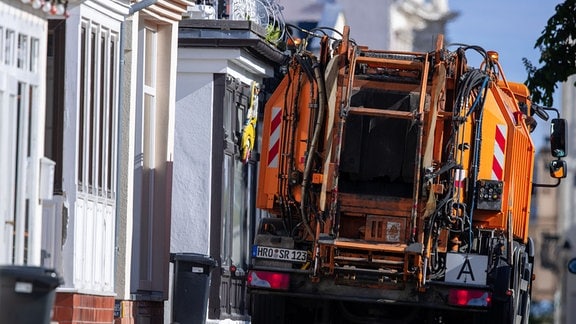 Ein Fahrzeug der Müllabfuhr ist in den engen Straßen in der Altstadt von Warnemünde unterwegs.