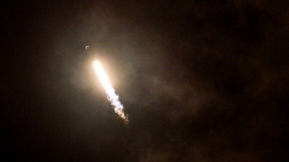 Eine Rakete startet in den Nachthimmel