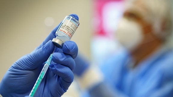 Ein Apotheker bereitet eine Spritze mit einer Dosis des Impfstoffs von Moderna vor.