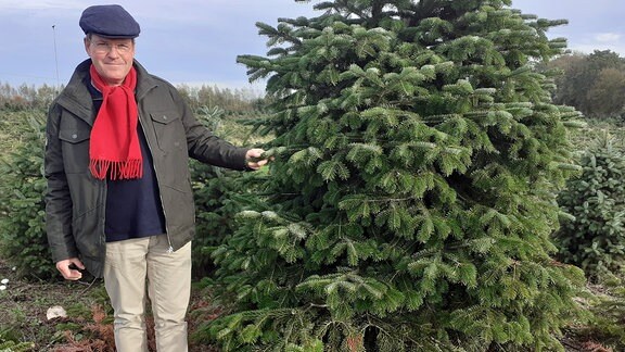 Weihnachtsbaumzüchter Ulrich Haberland neben einem Baum.