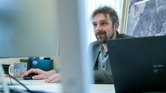 Ein Mann sitzt vor einem Computer